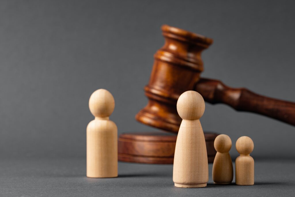 Wooden toy family and judge mallet. Family divorce concept